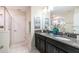 Bathroom with dual sinks, granite countertops, and a tiled shower at 1551 Observer Ln, Davenport, FL 33896