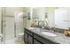 Well-appointed bathroom featuring dual sinks, granite countertops, and a glass-enclosed shower at 1551 Observer Ln, Davenport, FL 33896