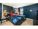 The bedroom has two custom beds, space-themed wallpaper, and a dark blue painted wall at 1551 Observer Ln, Davenport, FL 33896