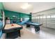 Expansive game room features air hockey, foosball table, and overhead garage door for easy access at 1551 Observer Ln, Davenport, FL 33896
