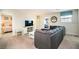 Upstairs living room with a comfortable gray sofa, entertainment center, and connecting bedrooms at 1551 Observer Ln, Davenport, FL 33896