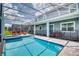 The pool is surrounded by seating and is equipped with a safety fence at 1551 Observer Ln, Davenport, FL 33896