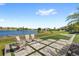 Tranquil backyard view with lounge chairs, lake views, and well manicured artificial turf at 15633 Panther Lake Dr, Winter Garden, FL 34787