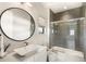 Modern bathroom featuring a round mirror, stylish vanity, and a tiled shower with glass door at 15633 Panther Lake Dr, Winter Garden, FL 34787