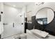 Modern bathroom featuring tiled shower, hexagon tile accent wall, floating vanity, and round mirror at 15633 Panther Lake Dr, Winter Garden, FL 34787