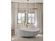 Contemporary bathroom featuring a free-standing tub under natural light at 15633 Panther Lake Dr, Winter Garden, FL 34787