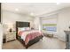 Stylish bedroom features a tufted headboard, serene lake views, and plenty of natural light at 15633 Panther Lake Dr, Winter Garden, FL 34787