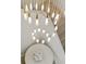 Close up view of a stunning chandelier above a staircase and table with flowers at 15633 Panther Lake Dr, Winter Garden, FL 34787