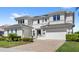 Elegant two-story home featuring manicured landscaping, a brick-paved driveway, and a three-car garage at 15633 Panther Lake Dr, Winter Garden, FL 34787