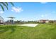 A community sand volleyball court next to a playground and surrounded by lush green grass at 15633 Panther Lake Dr, Winter Garden, FL 34787