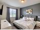 Modern bedroom featuring a large window with a TV, comfortable bed, and stylish decor at 1673 Moon Valley Dr, Davenport, FL 33896