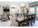 Formal dining room with large wood table, decorative place settings, and modern light fixture at 1673 Moon Valley Dr, Davenport, FL 33896