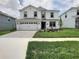 Charming two-story home with a well-manicured lawn, paved driveway and a two car garage at 1673 Moon Valley Dr, Davenport, FL 33896