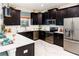 Well-equipped kitchen with stainless steel appliances, dark cabinetry, and sleek countertops at 1673 Moon Valley Dr, Davenport, FL 33896