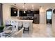 Modern kitchen with stainless steel appliances, dark cabinetry, a white countertop, and barstool seating at 1673 Moon Valley Dr, Davenport, FL 33896
