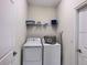 Efficient laundry room featuring a washer, dryer, and shelving for storage at 1673 Moon Valley Dr, Davenport, FL 33896