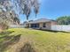 Backyard showing mature trees and lawn extending from patio and deck at 1913 Lazy Oaks Loop, St Cloud, FL 34771