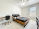 Modern bedroom with light floors, a ceiling fan, a sleek bed frame and a desk area at 1913 Lazy Oaks Loop, St Cloud, FL 34771