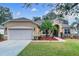 Charming single-story home featuring a manicured lawn, complemented by a two-car garage at 1913 Lazy Oaks Loop, St Cloud, FL 34771