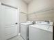 A well-lit laundry room featuring a washer, dryer, wire shelving and tile floors at 1913 Lazy Oaks Loop, St Cloud, FL 34771