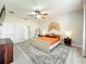 Bright primary bedroom features light floors, a ceiling fan, and stylish decor over a patterned area rug at 1913 Lazy Oaks Loop, St Cloud, FL 34771