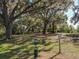 Lush park featuring mature trees, green space, waste disposal station, and a humorous sign at 1913 Lazy Oaks Loop, St Cloud, FL 34771