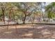 A playground with swings set against a backdrop of mature trees and community homes at 1913 Lazy Oaks Loop, St Cloud, FL 34771