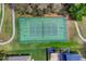 Aerial view of a tennis court surrounded by greenery, and a sidewalk and located near residences at 1913 Lazy Oaks Loop, St Cloud, FL 34771