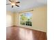 Bright bedroom featuring a ceiling fan, wood floors, and a large window offering ample natural light at 1960 Evard Ave, Deltona, FL 32725