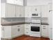 Bright kitchen featuring white cabinetry, stainless appliances, and hardwood floors at 1960 Evard Ave, Deltona, FL 32725