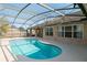 Inviting screened-in pool area with clear blue water and brick home exterior, perfect for relaxation at 1960 Evard Ave, Deltona, FL 32725