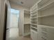 Walk-in closet with custom shelving, drawers and tile floors at 2010 Divot Dr, Daytona Beach, FL 32124