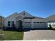Charming single-story home featuring a stone facade, a paver driveway, and a three-car garage at 2010 Divot Dr, Daytona Beach, FL 32124