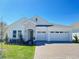 Charming single-story home featuring a stone facade, a paver driveway, and a three-car garage at 2010 Divot Dr, Daytona Beach, FL 32124