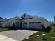 Charming single-story home featuring a stone facade, a paver driveway, and a three-car garage at 2010 Divot Dr, Daytona Beach, FL 32124