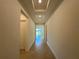 Well-lit hallway with trey ceiling leads to an open living space with neutral paint and tile floors at 2010 Divot Dr, Daytona Beach, FL 32124