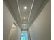Hallway with a tray ceiling leads to an open living space; with neutral paint and recessed lighting at 2010 Divot Dr, Daytona Beach, FL 32124