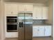 Bright kitchen features stainless steel appliances and white cabinets for a clean look at 2010 Divot Dr, Daytona Beach, FL 32124