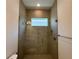 A modern tiled shower stall features a glass enclosure, small window and upgraded fixtures at 2010 Divot Dr, Daytona Beach, FL 32124