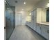 Bathroom with double vanity, storage, and a glass enclosed shower at 2013 Divot Dr, Daytona Beach, FL 32124
