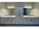 Elegant bathroom featuring double sinks with vanity, mirrors, and a central cabinet at 2013 Divot Dr, Daytona Beach, FL 32124