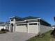 Angle view of home featuring a two-car garage with stone accents and a paver driveway at 2013 Divot Dr, Daytona Beach, FL 32124