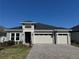 A beautiful single-story home featuring a two-car garage and stone accents and a paver driveway at 2013 Divot Dr, Daytona Beach, FL 32124