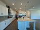 Bright kitchen features white cabinets, stainless appliances, a large island with quartz countertop and modern pendant lighting at 2013 Divot Dr, Daytona Beach, FL 32124