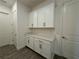 Beautiful laundry room featuring ample white cabinet storage and tile flooring at 2013 Divot Dr, Daytona Beach, FL 32124