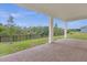 Covered back patio with brick pavers overlooking the landscaped backyard and green space at 2398 Nuthatch St, St Cloud, FL 34771