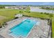 Aerial view of the community pool area with lounge chairs, palm trees, and lake views at 2398 Nuthatch St, St Cloud, FL 34771