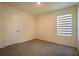 Simple bedroom design with plush carpeting, a bright window with blinds, and a white door at 2464 Ribbon Fall Ave, Davenport, FL 33837