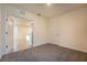 A cozy bedroom with neutral carpet, and a doorway that offers a glimpse of the kitchen at 2464 Ribbon Fall Ave, Davenport, FL 33837