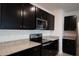 Well-equipped kitchen with stainless steel appliances, granite countertops, and dark wood cabinets at 2464 Ribbon Fall Ave, Davenport, FL 33837